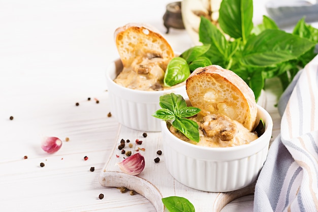 Baked mushroom julienne with chicken, cheese and toast in bowls