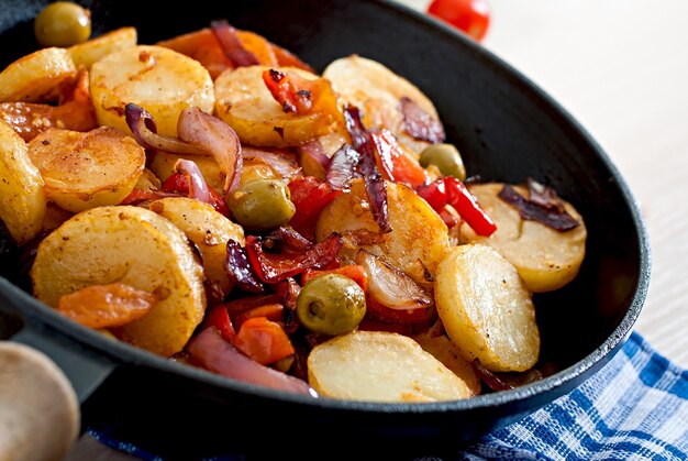 Baked potato with vegetables in a frying pan