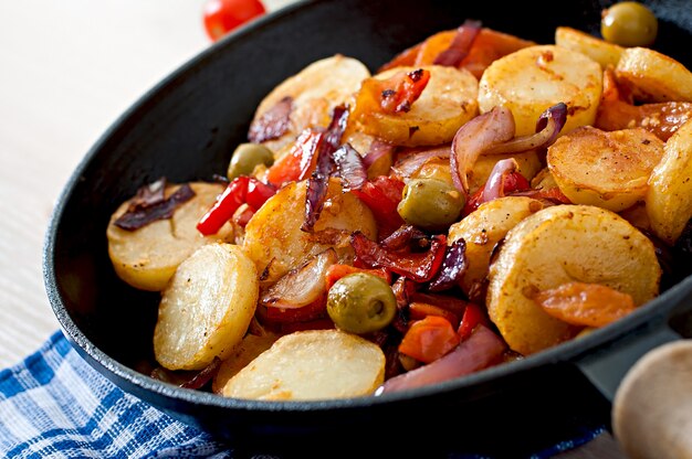 Baked potato with vegetables in a frying pan