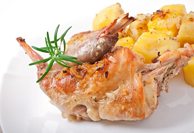 Baked rabbit legs with potatoes and rosemary