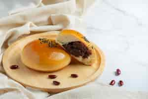 Free photo baked red bean paste buns on wooden plate