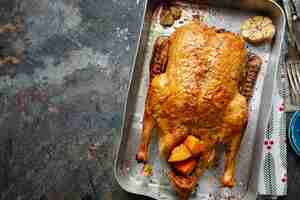 Free photo baked roasted duck with vegetables on pan on stone background. top view.