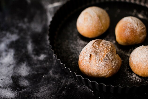Baked round bread in plate on marble textured backdrop