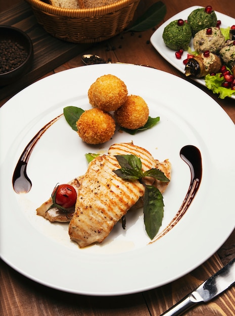 Filetto di salmone al forno con patate e panini al formaggio e verdure miste.