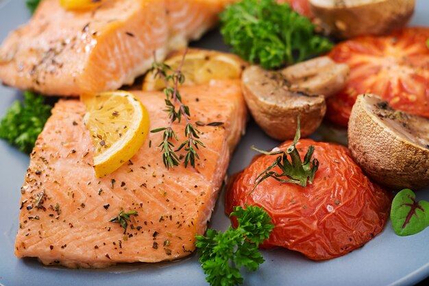 Baked salmon fish fillet with tomatoes, mushrooms and spices. Diet menu.