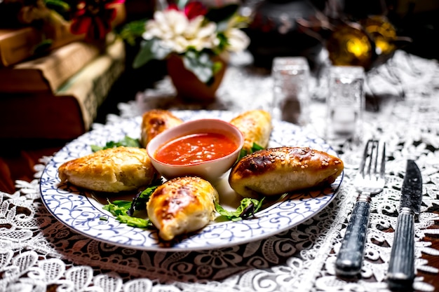 Foto gratuita pasta ripiena al forno con granelli di sesamo servita con salsa di pomodoro