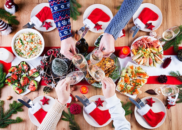 Baked turkey. Christmas dinner. The Christmas table is served with a turkey, decorated with bright tinsel and candles. Fried chicken, table.  Family dinner. Top view, hands in the frame