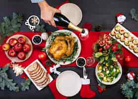 Free photo baked turkey. christmas dinner. the christmas table is served with a turkey, decorated with bright tinsel and candles. fried chicken, table.  family dinner. top view