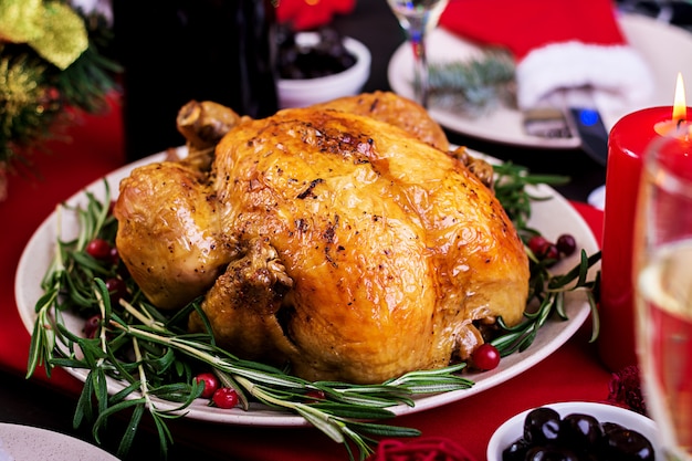 Baked turkey. Christmas dinner. The Christmas table is served with a turkey, decorated with bright tinsel and candles. Fried chicken, table.  Family dinner.