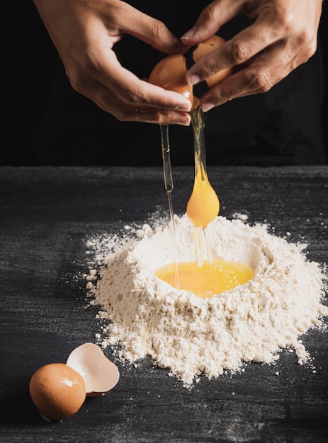小麦粉と卵黄を混合するパン屋の手