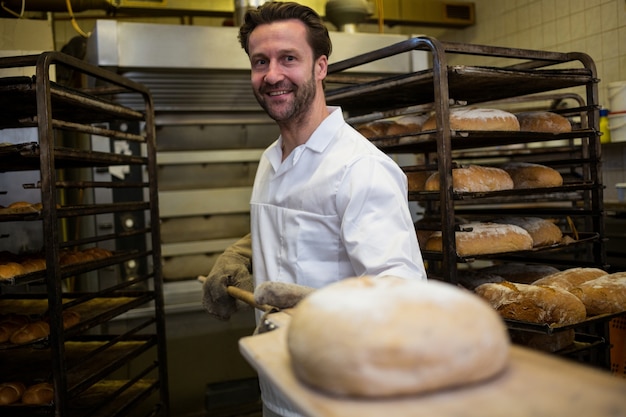 Baker keeping baked bread on counter