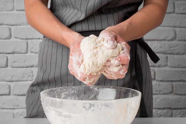 Baker kneading dough over bowl