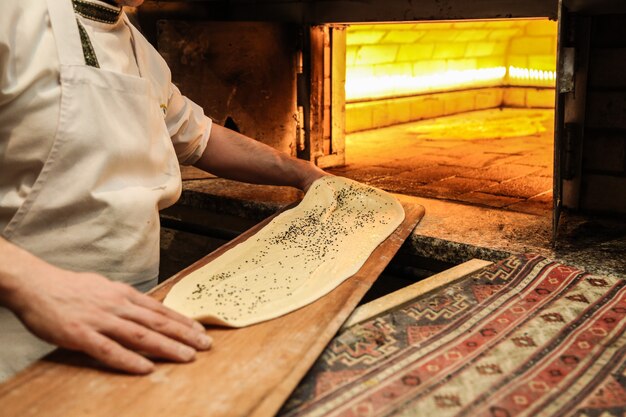 Baker makes some bread in oven