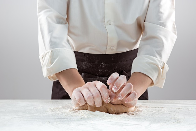 Free photo the baker making bread, male hands, kneading a dough, cooking coat