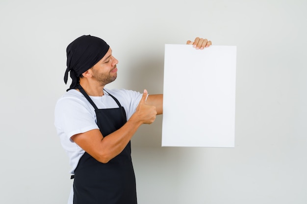 Free photo baker man holding empty canvas