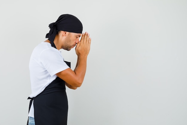 Baker man holding hands in praying gesture in t-shirt