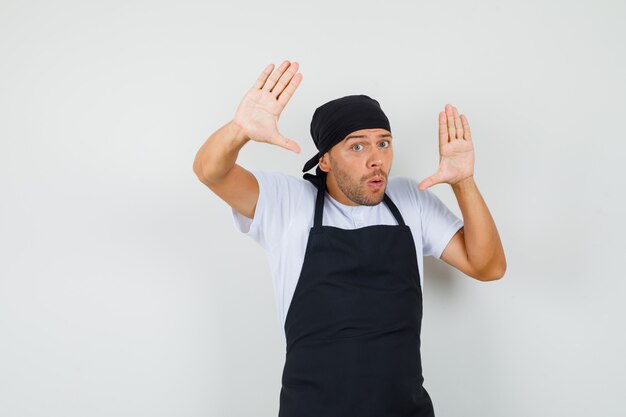 Baker man making surrender gesture in t-shirt