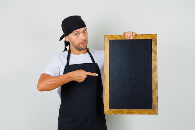 Baker man pointing at blackboard in t-shirt