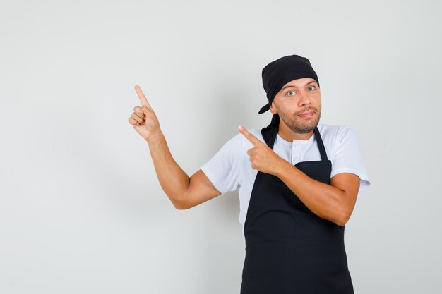 Baker man pointing to the side with fingers up in t-shirt