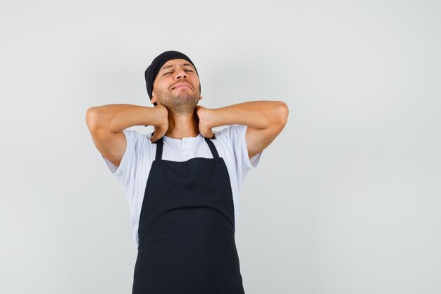 Free photo baker man suffering from neck pain in t-shirt