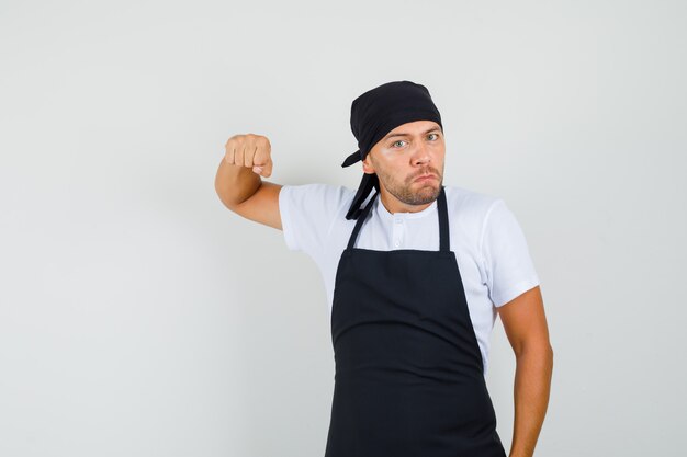 Tシャツ、エプロンで拳で脅し、激怒しているベイカー男