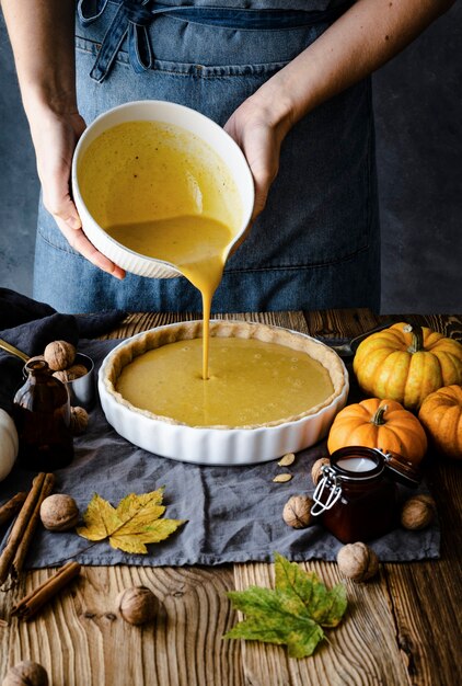 Baker pouring pumpkin puree into a plate closeup