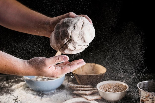 Free photo baker's hand kneading the dough