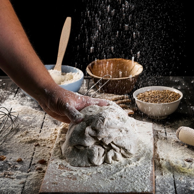Baker sprinkling the flour on the dough