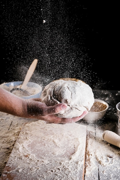 Бесплатное фото Пекари, разбрызгивающие муку над месильным тестом