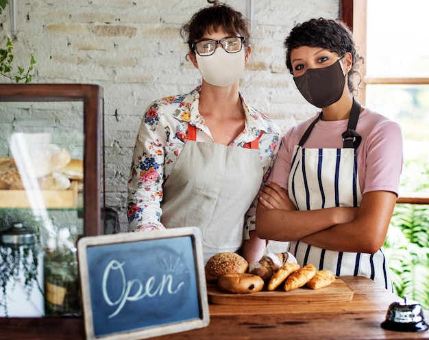 Free photo bakery shop open post covid pandemic new normal staff in face masks