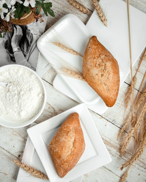 Panificio con panna acida e ramo di grano sul tavolo