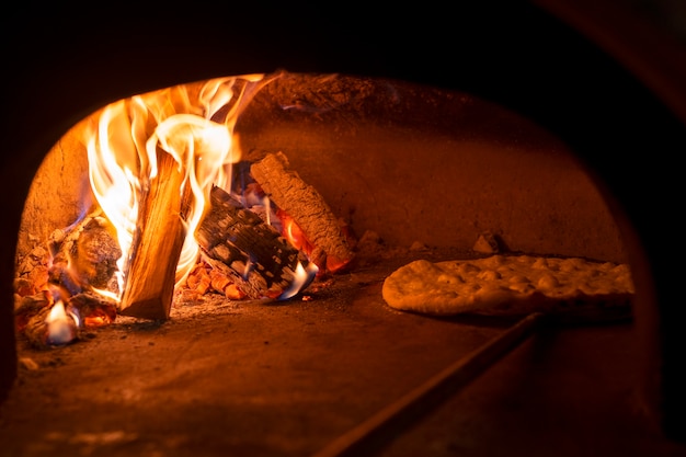 Baking delicious pizza with wood fired oven