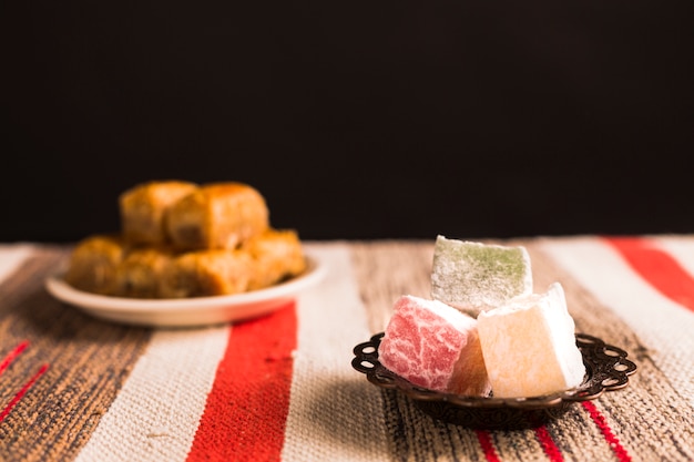 Baklava and Turkish delights on saucers against mat