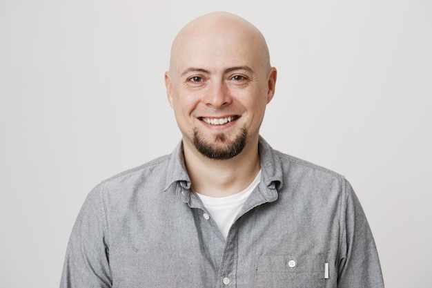 Bald smiling middle-aged man with beard looking