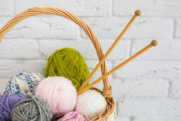 Ball of yarns with crochet in wicker basket