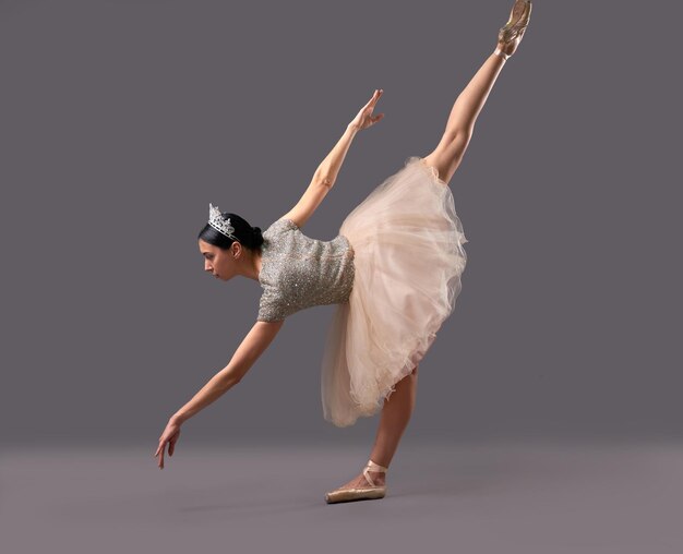 Ballerina bending down and raising one leg up in studio