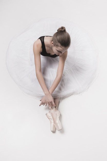 Ballerina dancer sitting down with her legs crossed