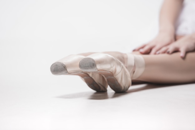 Балерина танцор сидит со скрещенными ногами