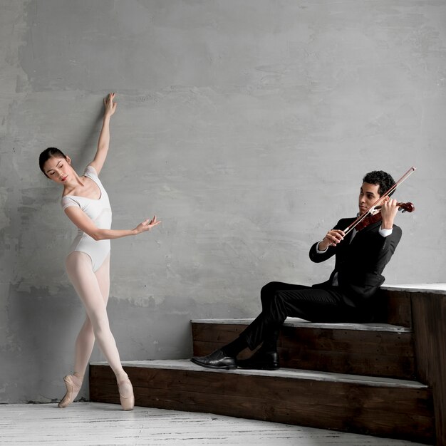Балерина танцует и играет на скрипке музыканта