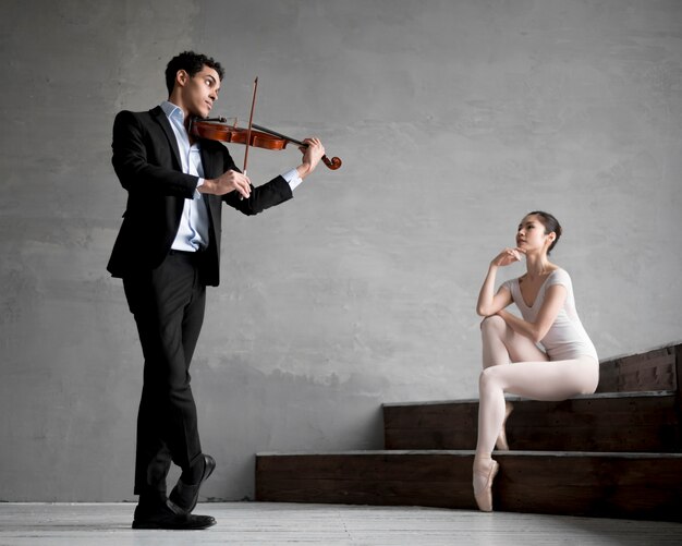 Балерина слушает музыканта, играющего на скрипке