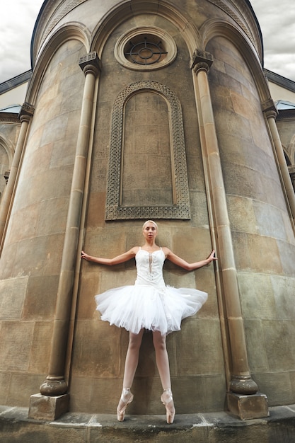 Free photo ballerina performing near an old castle
