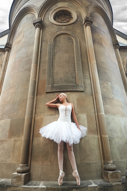 Free photo ballerina performing near an old castle