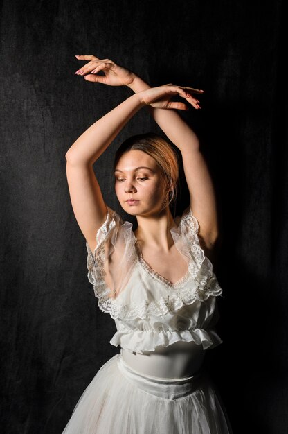 Ballerina posing in dress with arms up