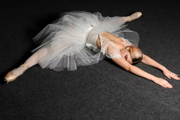 Ballerina posing while doing a split in tutu dress