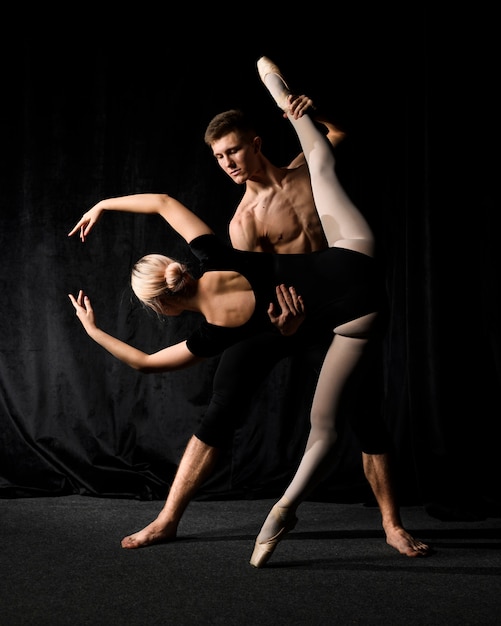 ballerina posing with man holding her leg