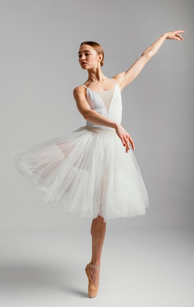 Ballerina standing with pointe shoes full shot