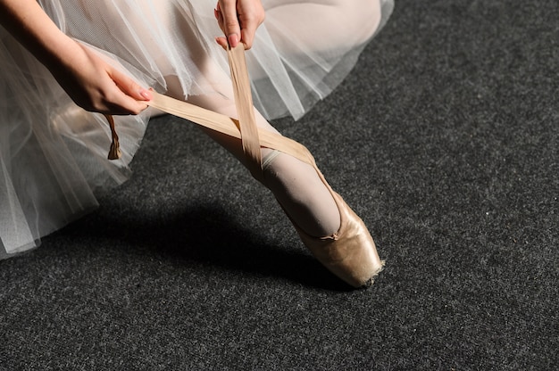 Ballerina che lega il nastro della sua scarpa da punta