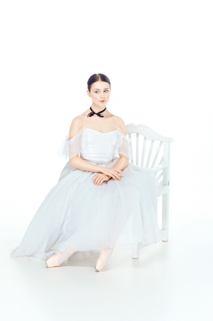 座っている白いドレス、スタジオスペースのバレリーナ。