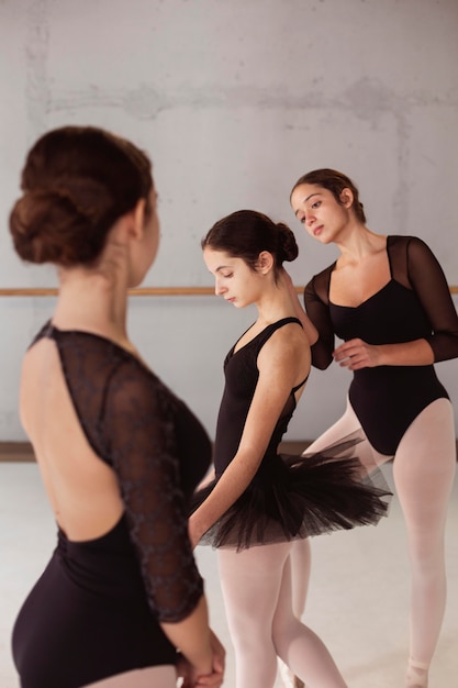 Ballerinas in tutu skirts and leotards preparing together for a performance