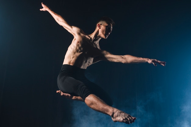 Ballerino dancing in tights with smoke